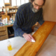 Photo of Gary Wood applying finish to a board