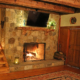 Photo of stone fireplace with live edge curly maple mantle